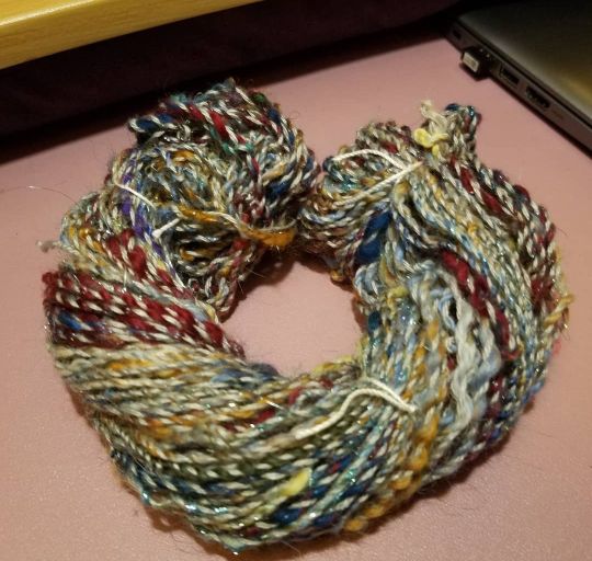 a random small skein of commercial grey yarn plied with a multicolored single I spun